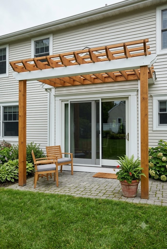 Shallow pergola attached above sliding patio doors with two front posts on a paver patio